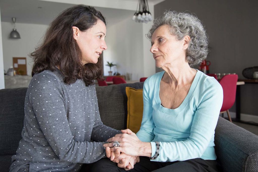 adult daughter talking to senior mother