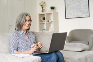 woman sitting with laptop in educational program for seniors