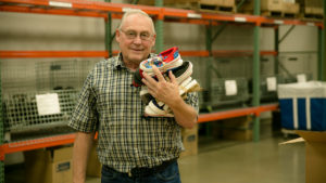 old man holding shoes