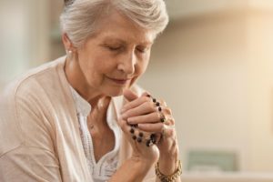 a person bows their head to pray in a chaplaincy program
