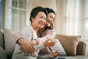 senior mom and daughter embracing after finding tips for paying for senior living
