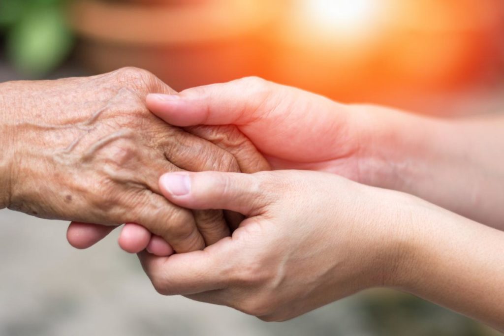 two pairs of hands embrace possibly after the people discussed memory care benefits