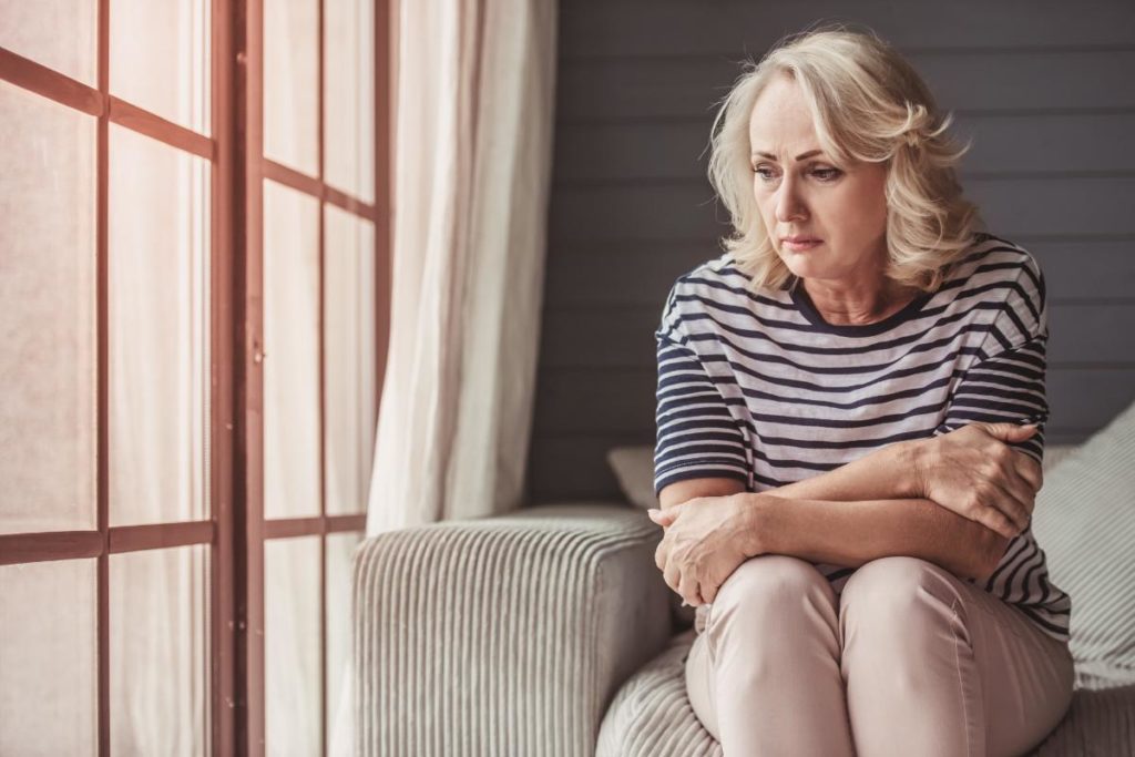 a person looks out of a window as they struggle with anxiety in seniors