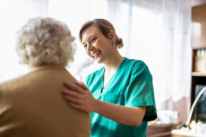a nurse with a Senior Health Care Career helps a senior in a bed