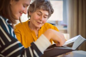 Elderly woman and caretaking discussing benefits of dementia care