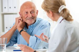 Smiling man with caregiver in speech therapy reaping the speech therapy benefits