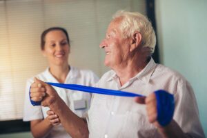 Happy senior learning what occupational therapy is while in session with a happy caregiver