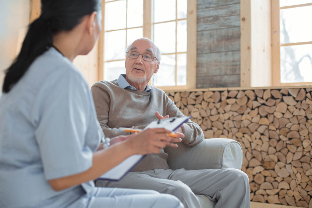 caretaker and senior man discussing the importance of mental health awareness in senior living