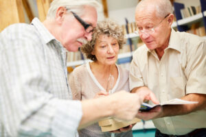 group of seniors browsing catalog of educational programs in senior living