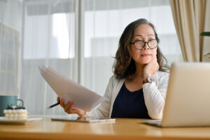 person sitting at table using laptop while researching the financial aspects of respite care