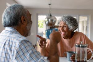 two seniors talking and laughing while enjoying daily life in a memory care center